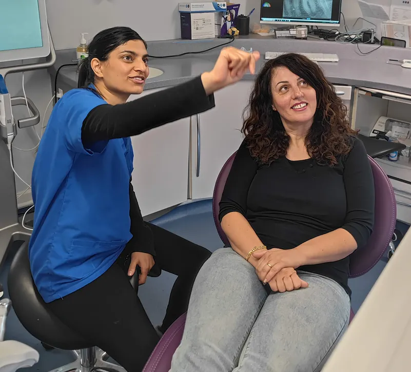 Dr Neeshita Ruparel talking with a patient in the dental chair