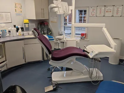 A treatment room at Thames Street Dental with a burgundy dental chair