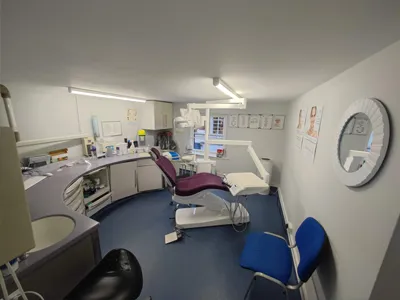 Wide view of a Thames Street Dental treatment room with the dental chair and wall clock
