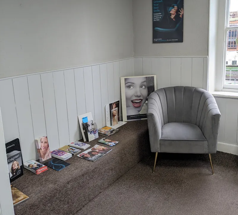 An armchair and magazine shelf in the first-floor waiting room