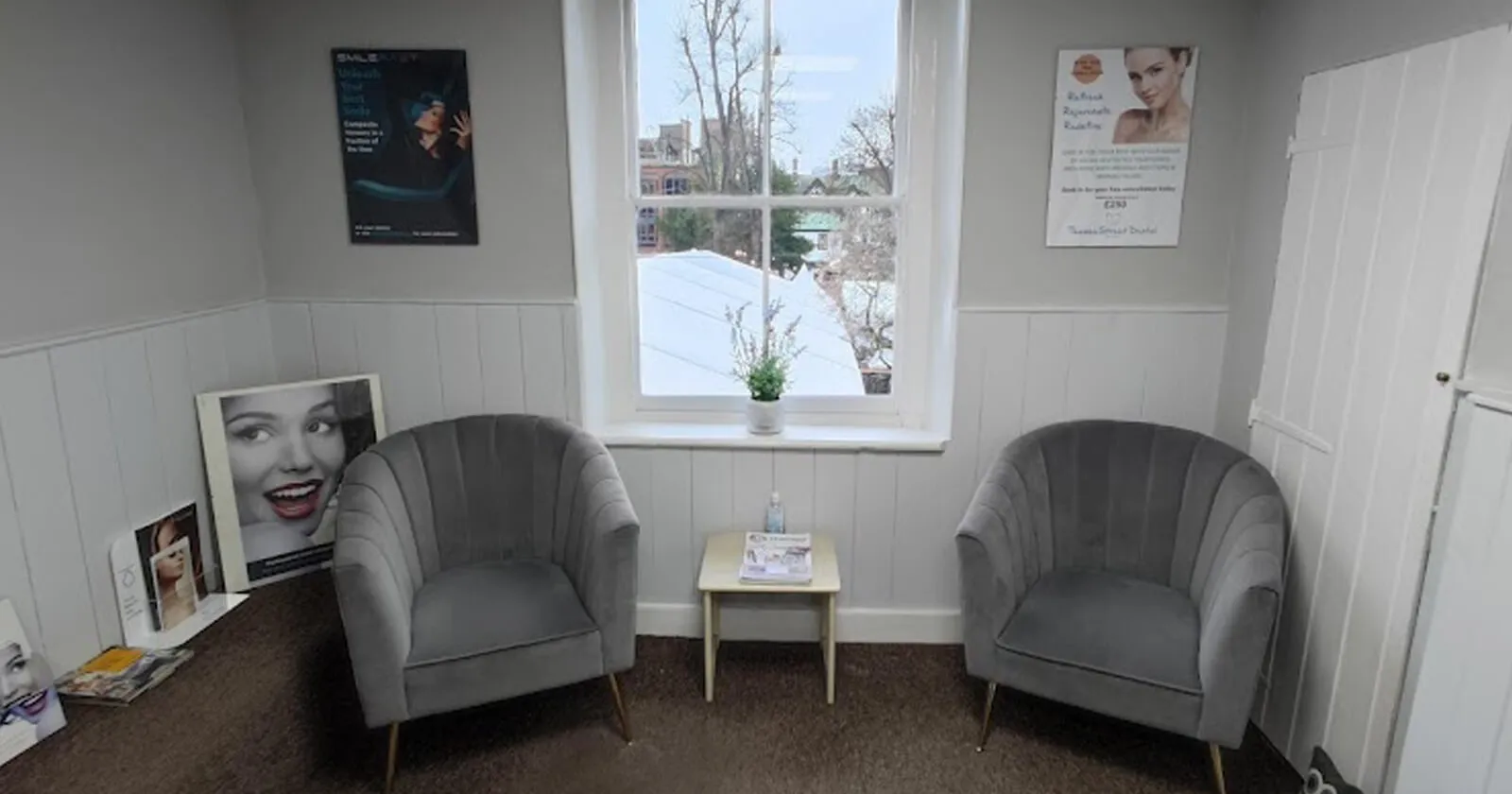 The Thames Street Dental waiting room with grey armchairs and a sash window